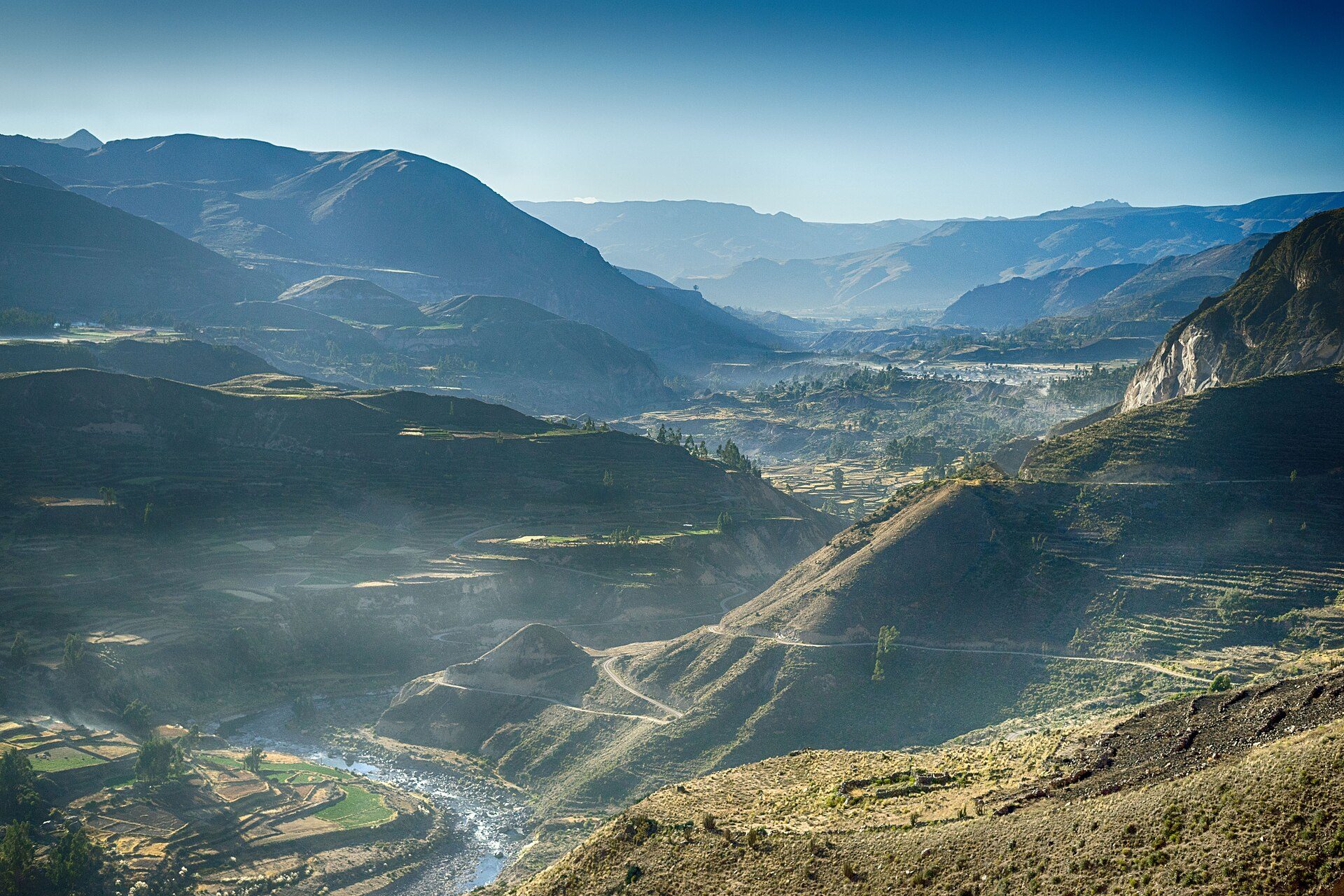 Trekker overlooking the terraced depths of the Colca Canyon at sunrise