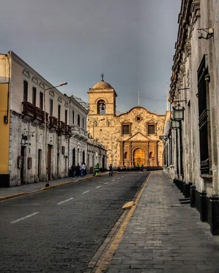 Locals crossing Arequipa's Plaza de Armas as evening light hits the cathedral towers